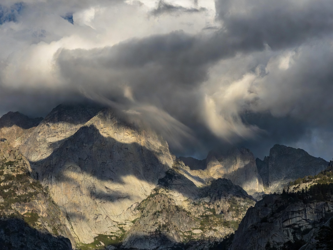 Cloud shadows moving over mountain cliffs during changing weather conditions